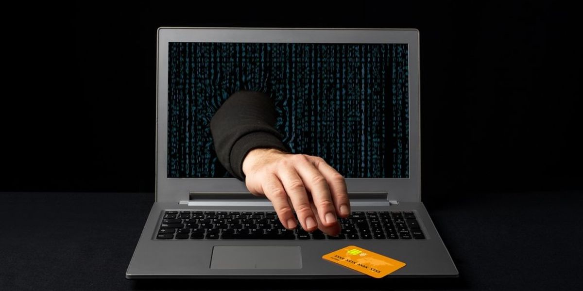 Online csakó átnyúl egy laptopon, hogy ellopja egy online vásárló hitelkártyáját