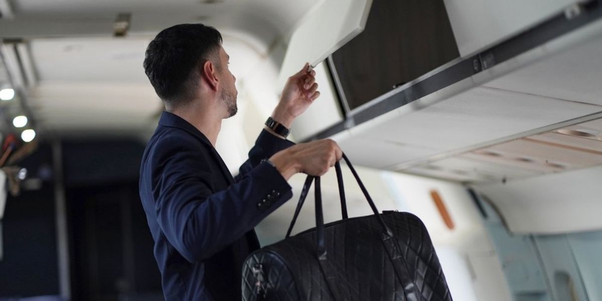Csomagját felpakoló utas a kabinban