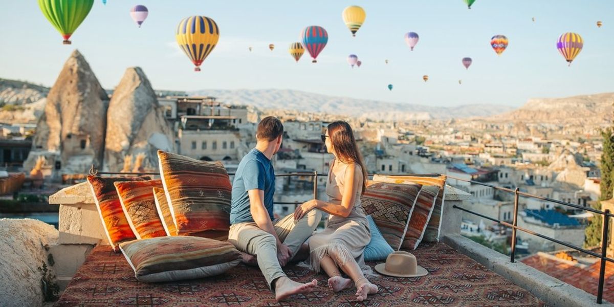 egy pár nézi a hőlégballonokat Kappadókiában, Törökországban