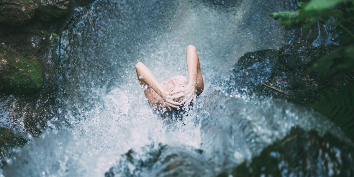 egy nő zuhanyzik hideg vizzel egy forrásnál