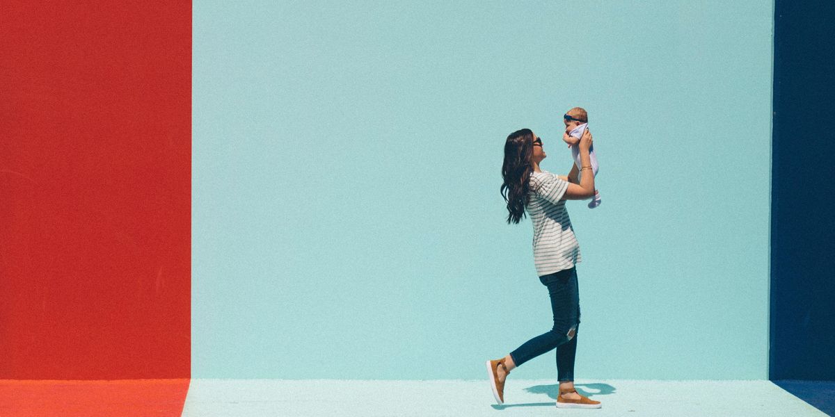 woman carrying baby while walking