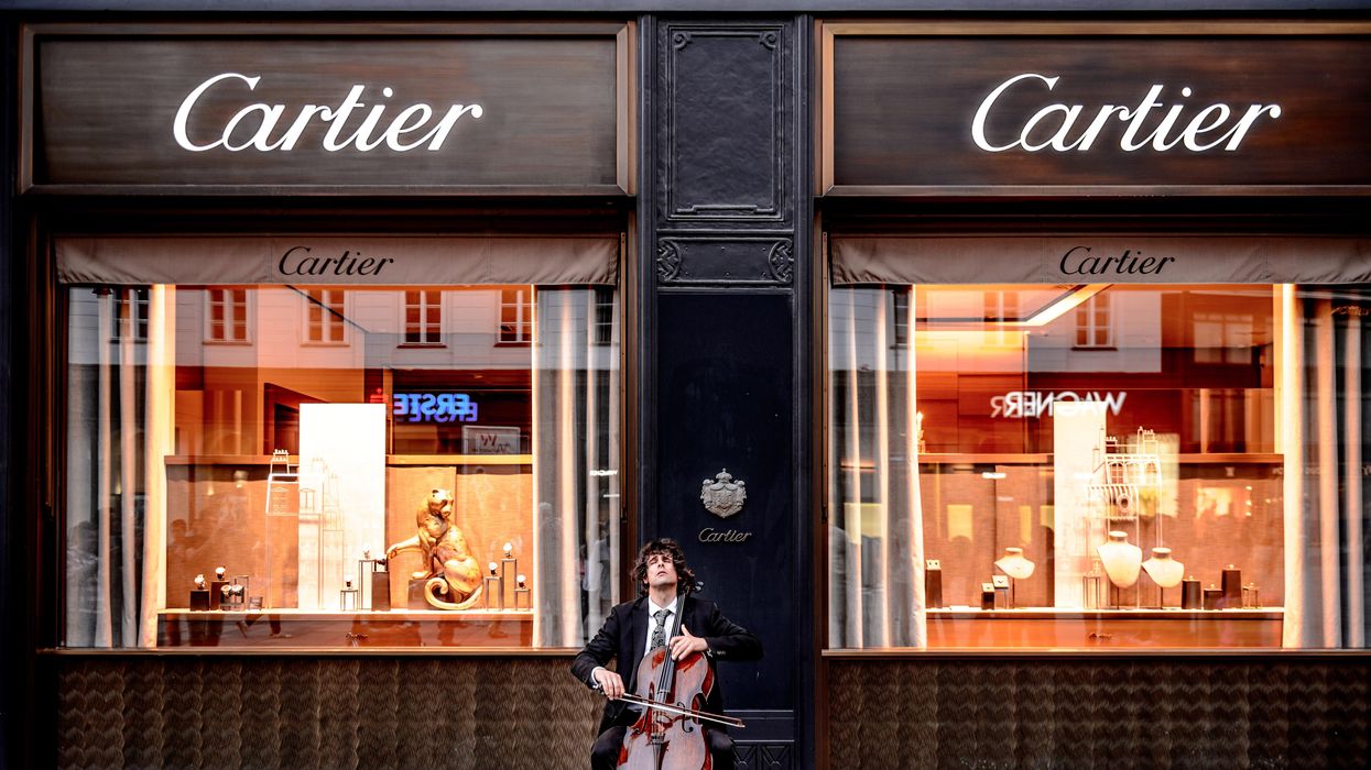 egy fiatal fiu zenél egy Cartier üzlet előtt