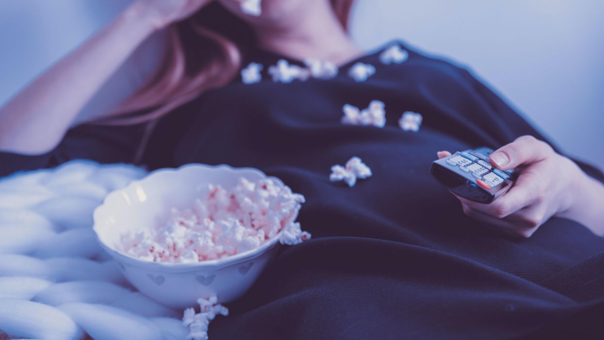 Netflixet néző lány pattogatott kukoricával a kezében