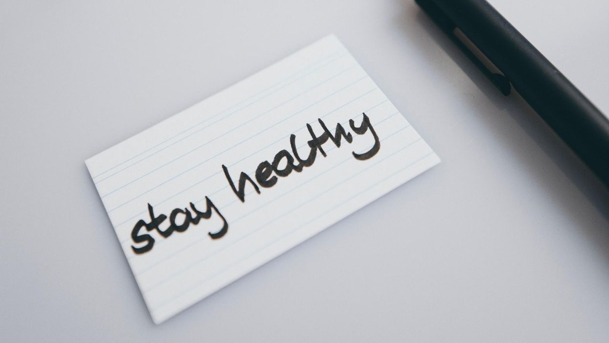 „Maradj egészséges!" felirat egy papírcetlin egy toll mellett