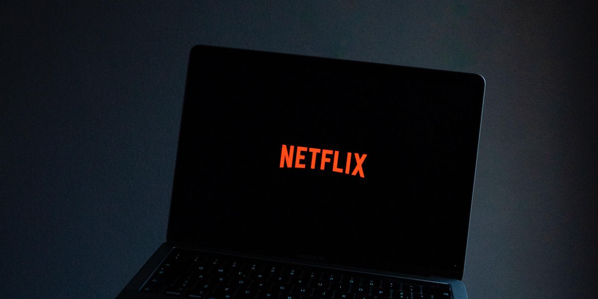 valaki egy laptopot tart a kezében amin a Netflix van bekapcsolva