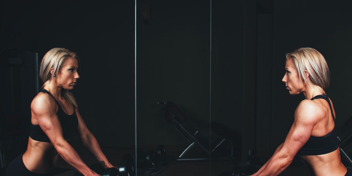 Egy nő a tükörben saját magával néz szembe az edzőteremben