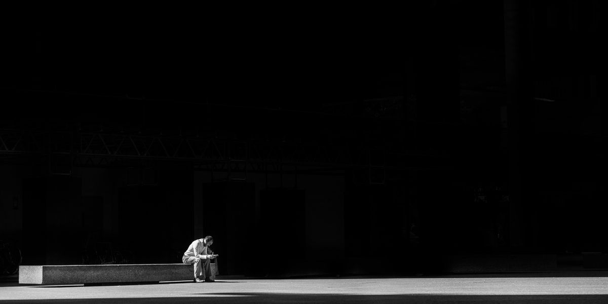 Egy férfi egyedül ül a sötétben