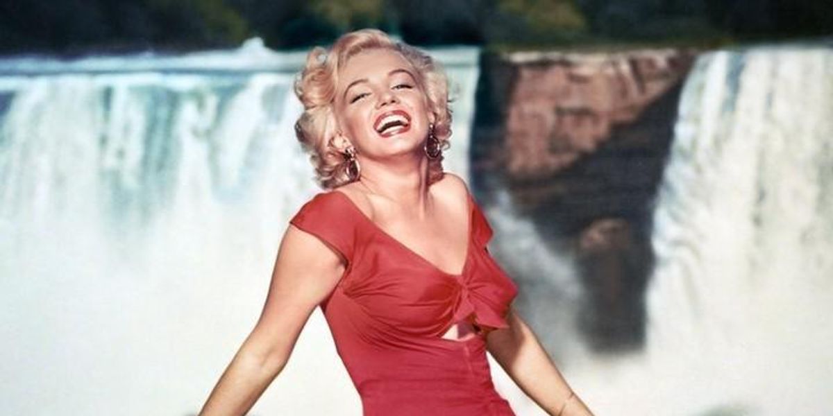 Marilyn Monroe piros ruhában egy vízesés előtt