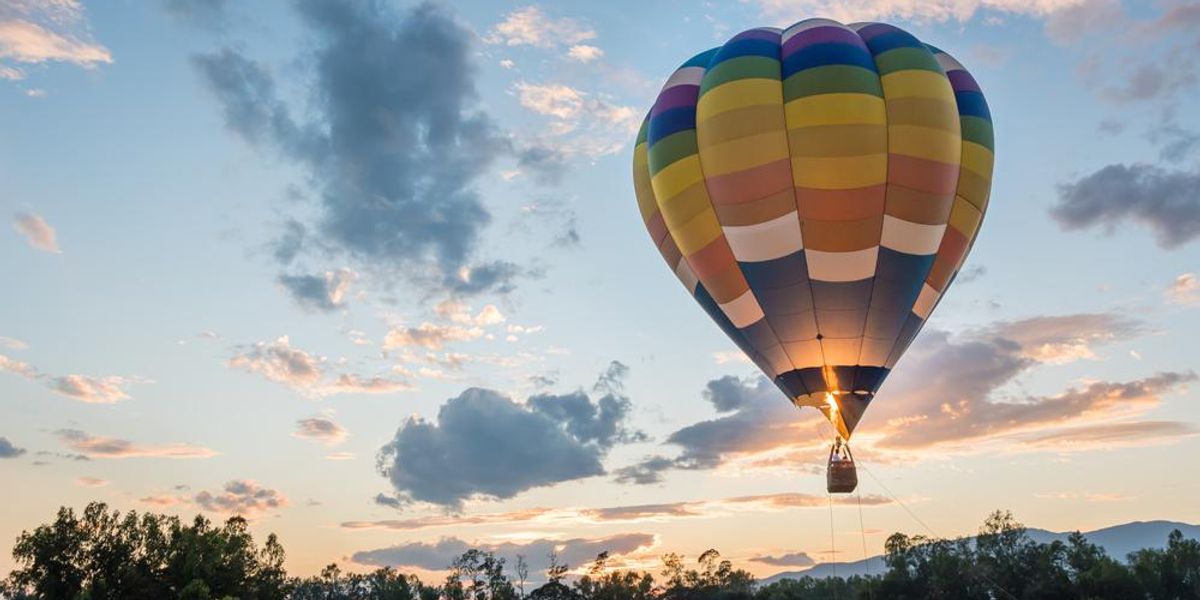 Hőlégballon repül napkeltekor