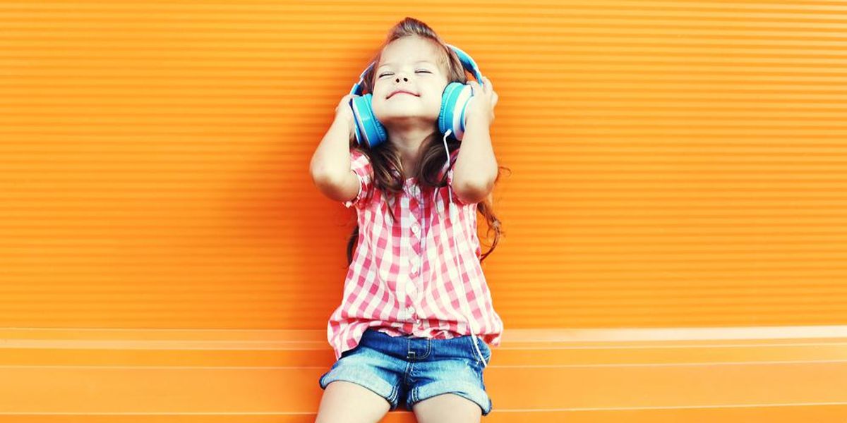 Boldog kislány élvezettel hallgat zenét 