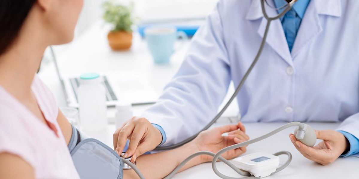 Orvos ellenőrzi női beteg vérnyomását