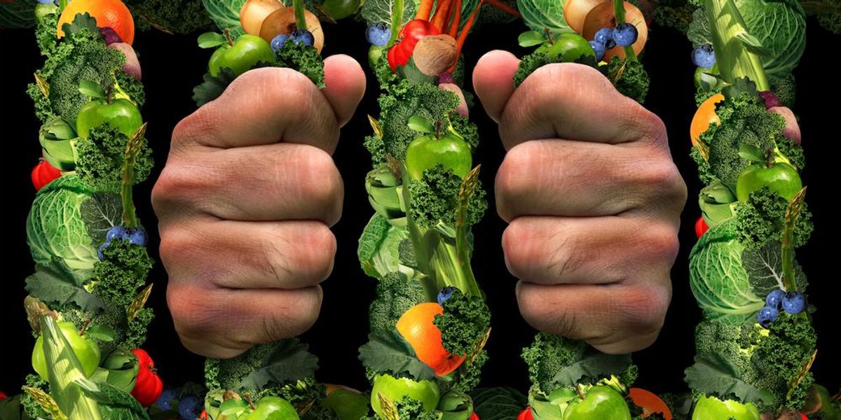 Egészséges táplálkozási megszállottság, az egészséges ételek börtönrácsait fogó kéz szimbóluma
