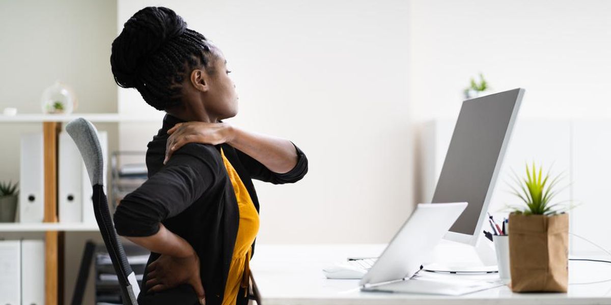 Irodájában ülő nő hátfájással küzd