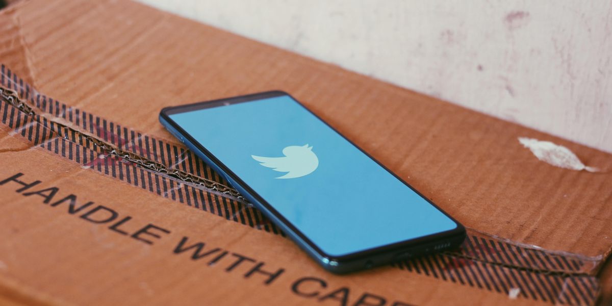 Egy dobozon fekvő telefonon meg van nyitva a Twitter alkalmazása