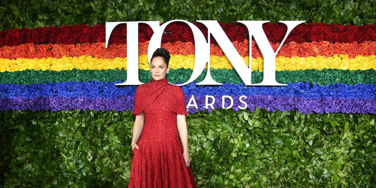 Tony Awards vörös szőnyegén piros ruhában áll egy nő
