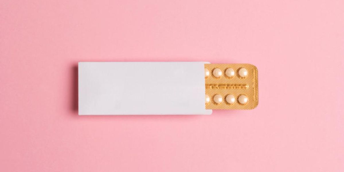 Női orális fogamzásgátló tabletta rózsaszín háttéren