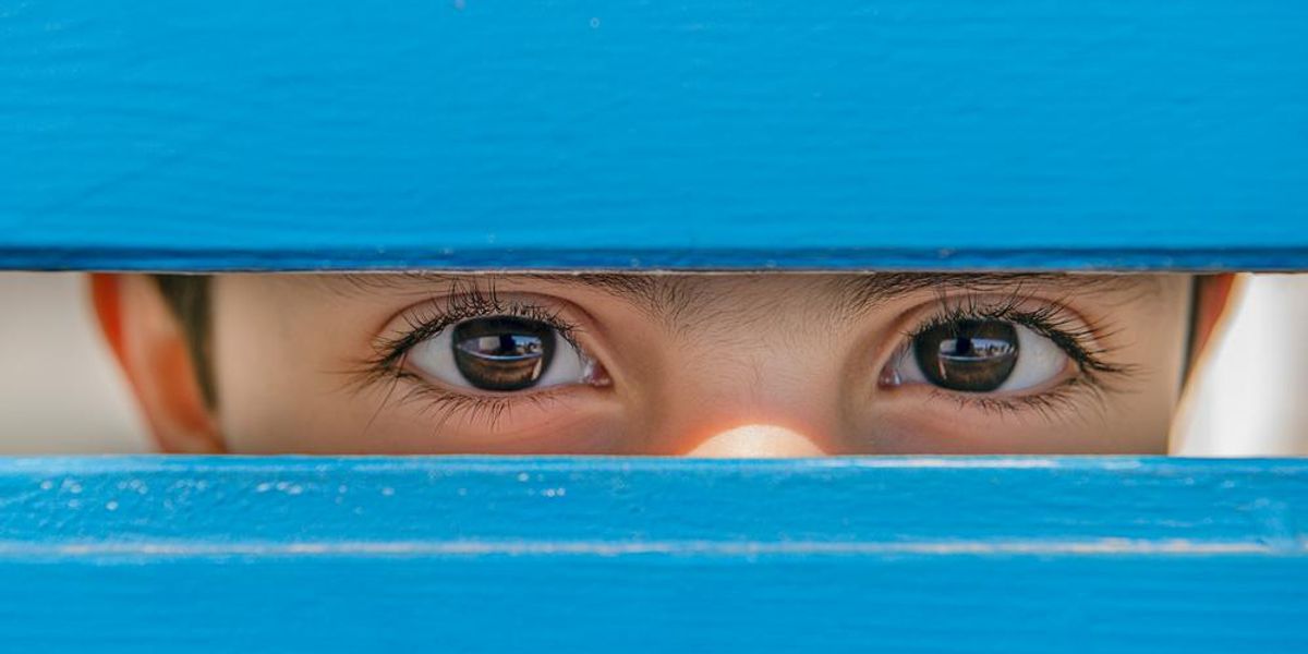 Kisfiú szemei kék fadeszkák között