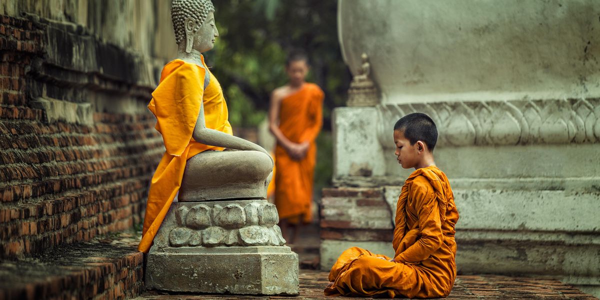 kis tibeti szerzetes tanonc Buddha szobra előtt