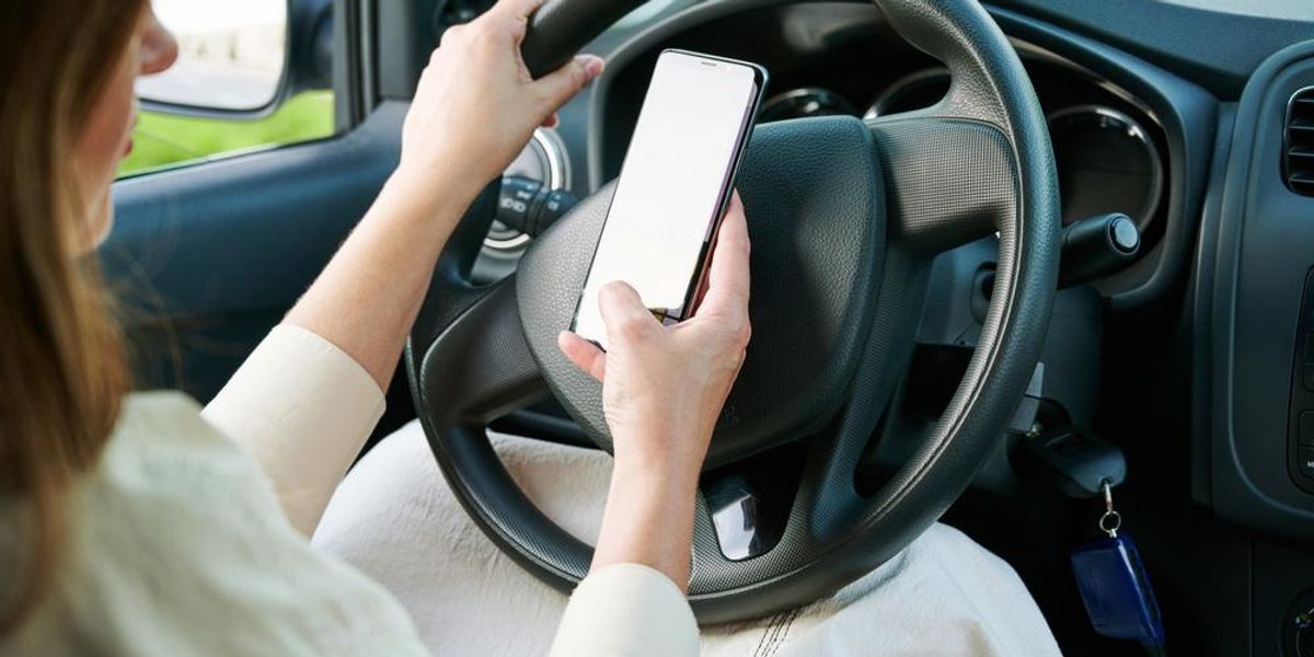 Kocsiban ülő nő telefonozik