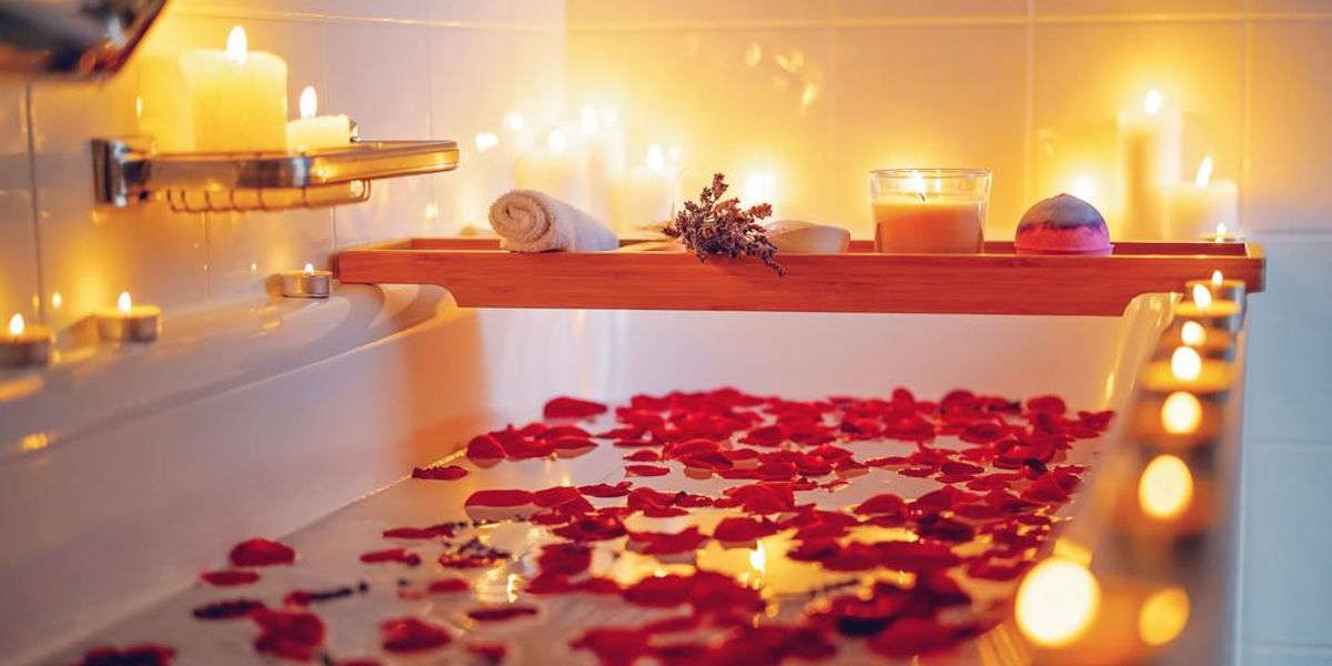 Spirituális virágfürdő gyertyákkal, aromasóval, levendulával és rózsaszirmokkal