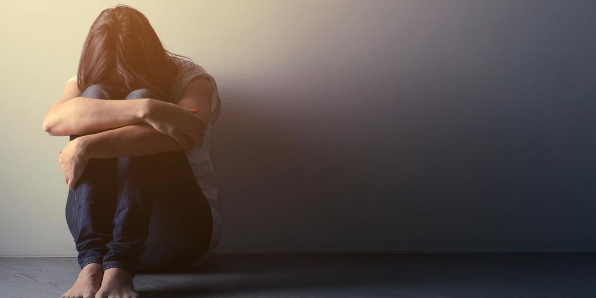 Depressziós kamaszlány ül egyedül a padlón