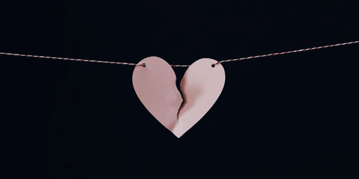 Egy papírból kivágott törött szív, felfűzve egy cérnára