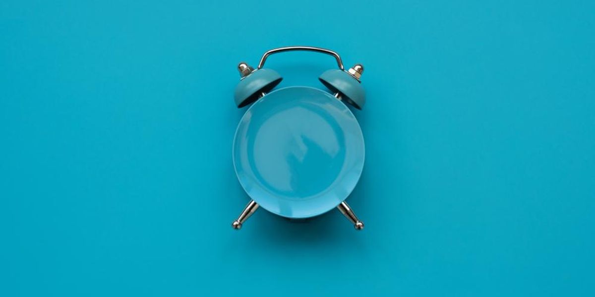 Üres tányér mint óra kék háttéren