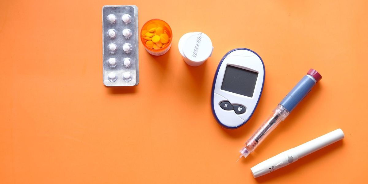 inzulin, diabetikus mérőeszközök és tabletták narancssárga háttéren