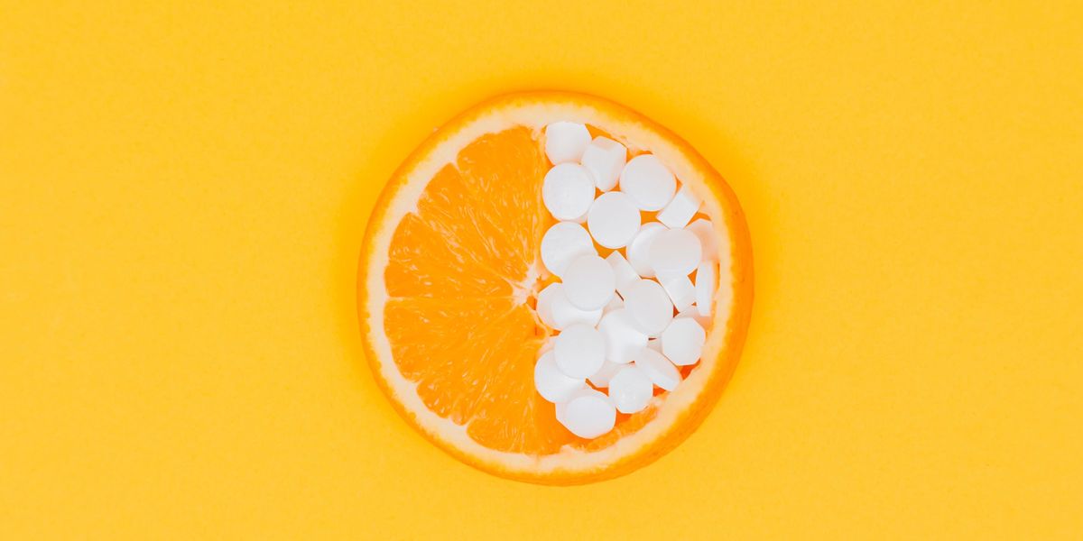 Egy narancs, aminek az egyik felébe C-vitamintablettákat tettek