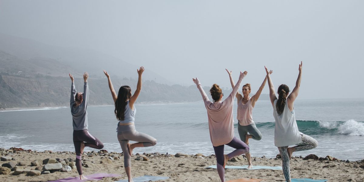 Nők együtt jógáznak a strandon
