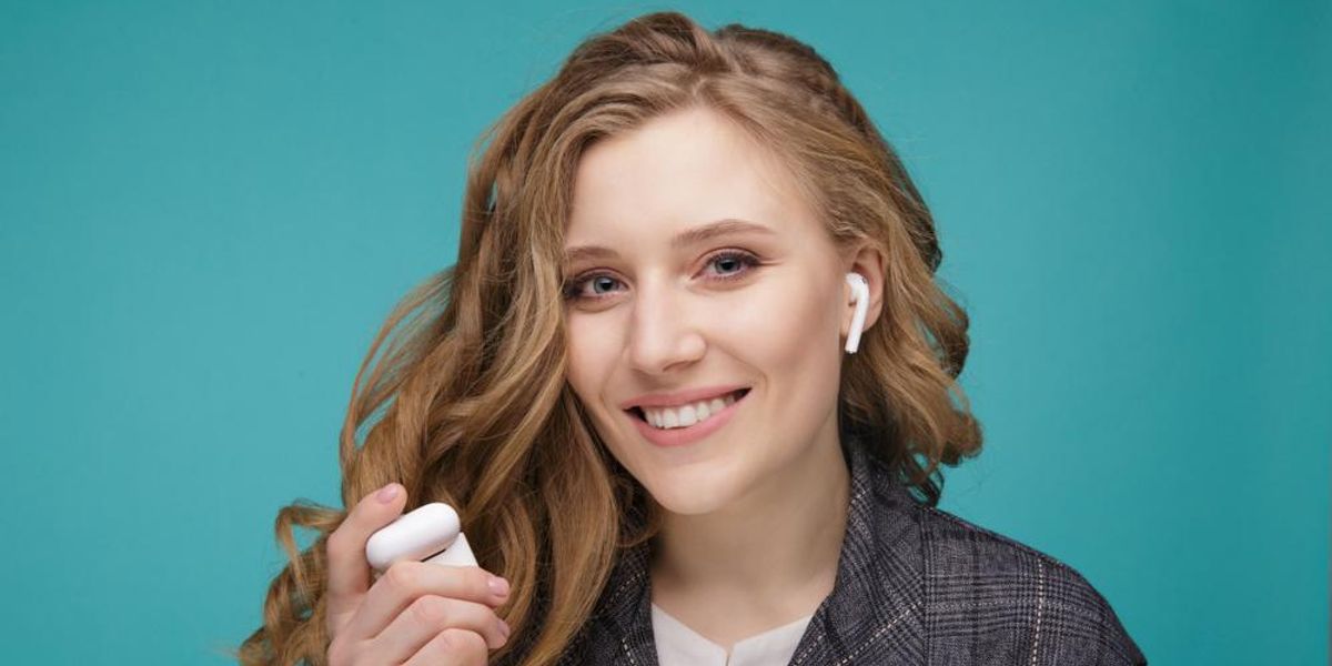 Apple AirPods vezeték nélküli fülhallgatón zenét hallgató nő