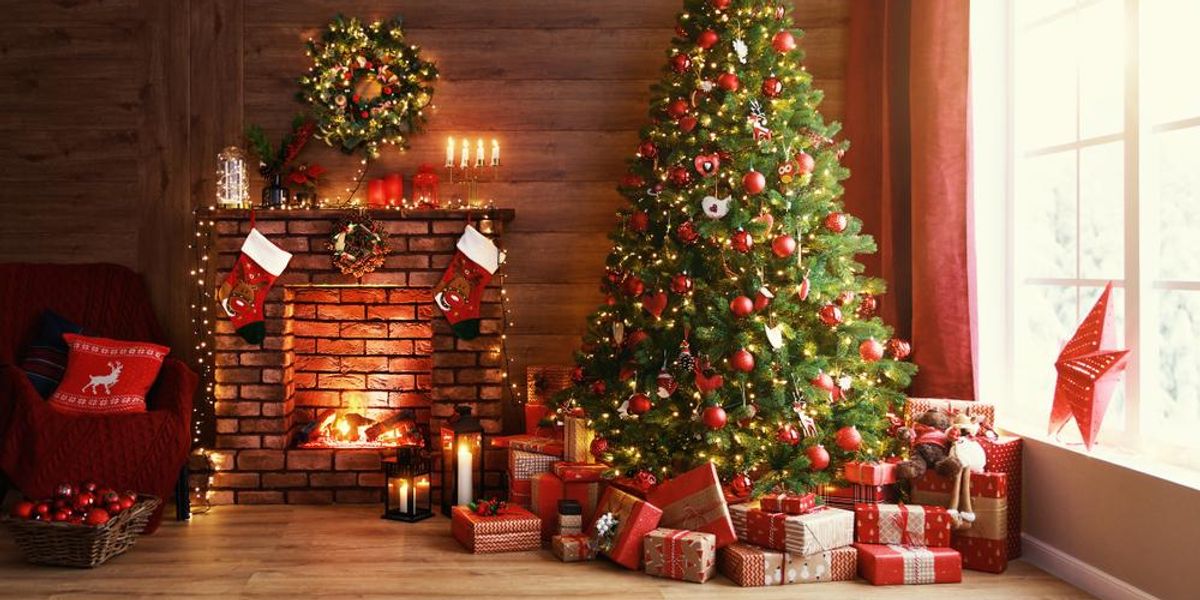 Feldíszített karácsonyfa, körülötte ajándékok és kandalló