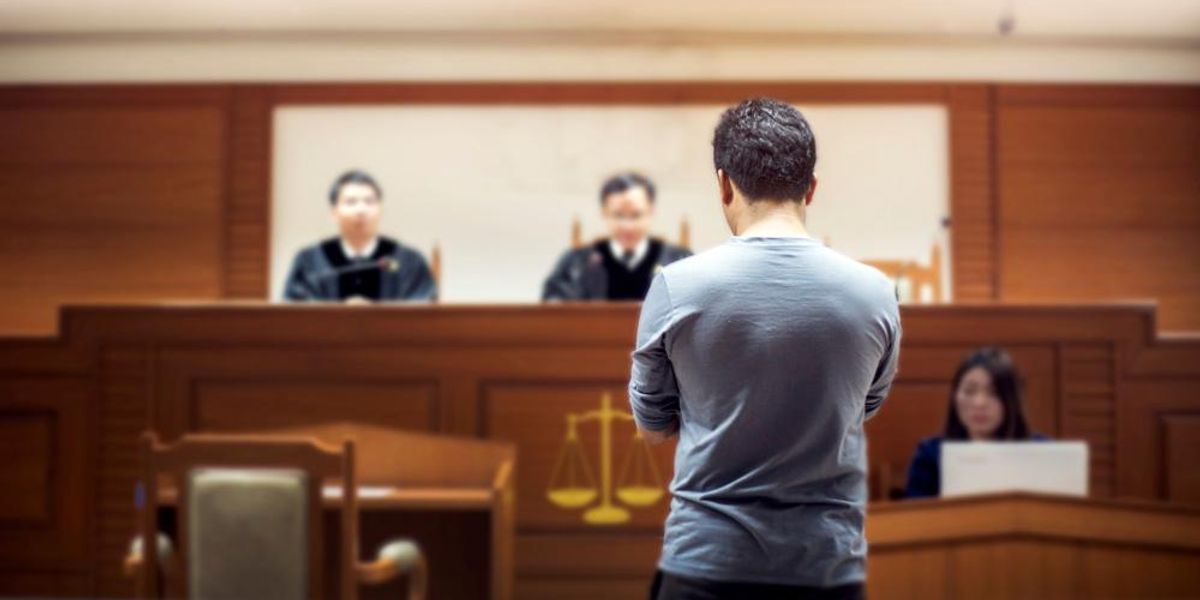 Bíróságon áll egy szürke pólós férfi