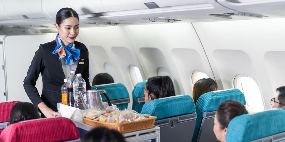 Légiutas-kísérő ételt és italt szolgál fel az utasoknak a repülőgépen