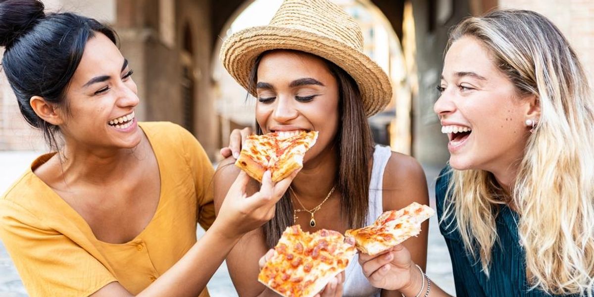 Pizzát evő, vidám barátnők Rómában