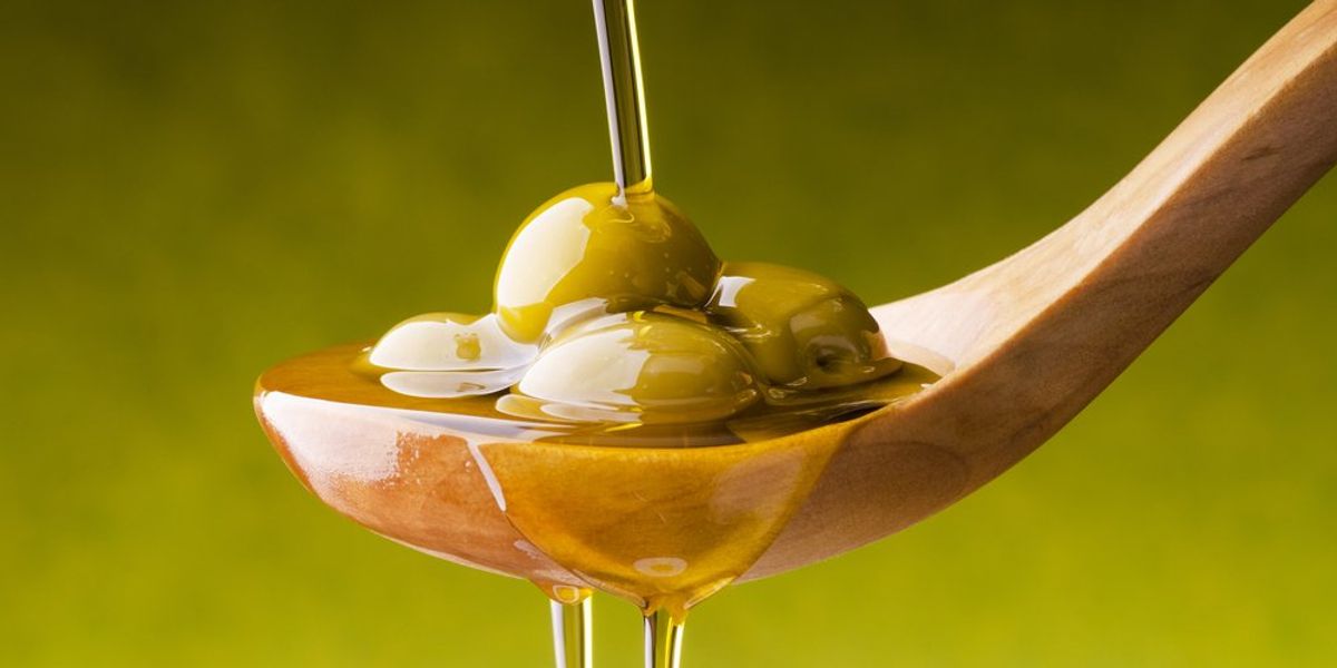 Extra szűz olívaolaj és olívabogyók fakanálon