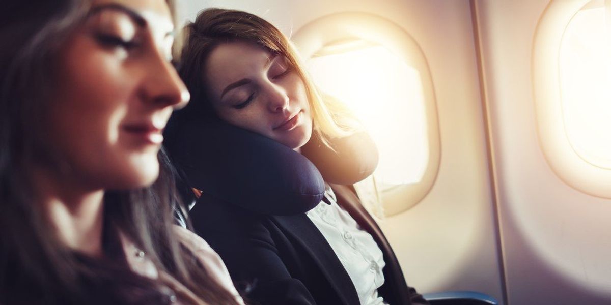 Egy lány alszik a repülőn