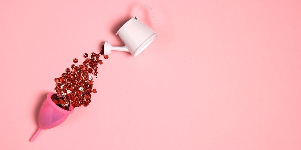 Menstruációs kehelybe egy kis locsolókannából vörös csillámokat öntenek