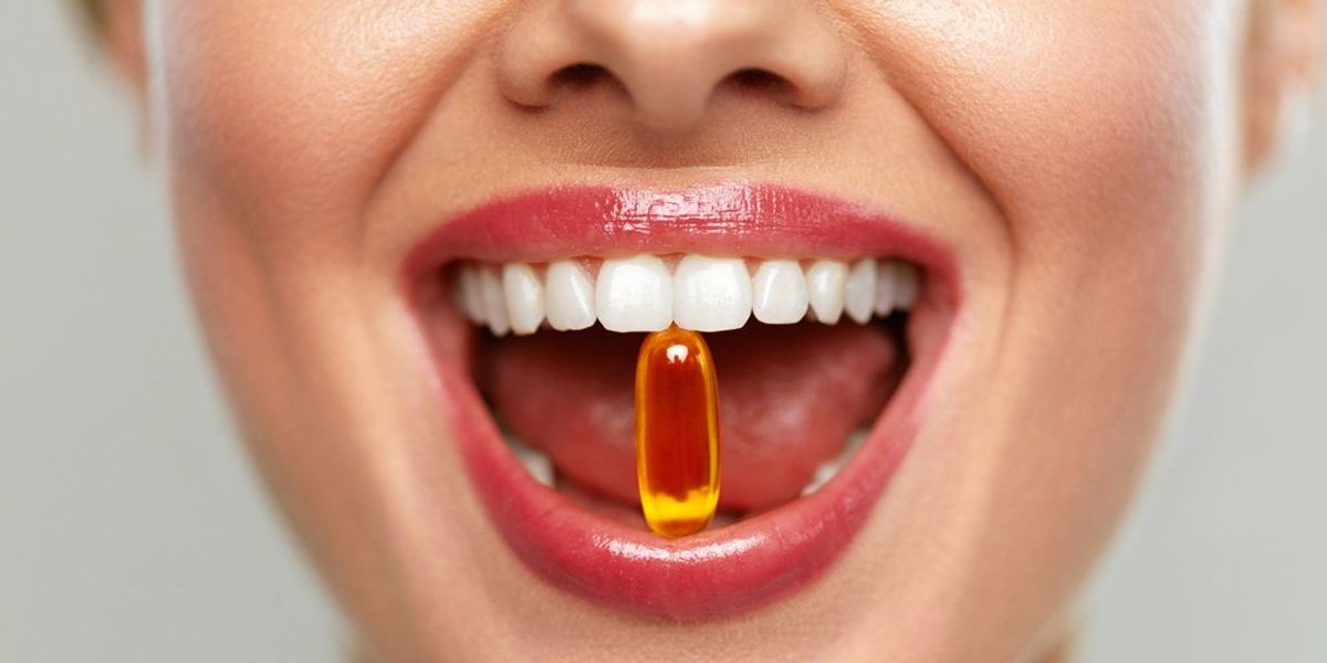 Vitamint a fogai közt tartó női száj