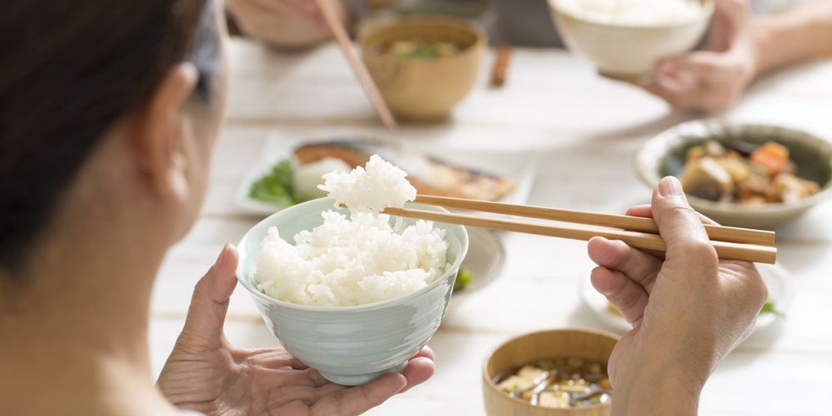 Rizst eszik pálcika evőeszközzel egy japán nő