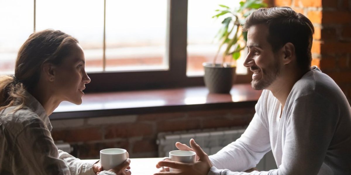 Kávézóban egymással szemben ülő és beszélgető pár