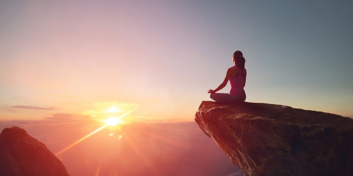 Hegyen meditáló nő