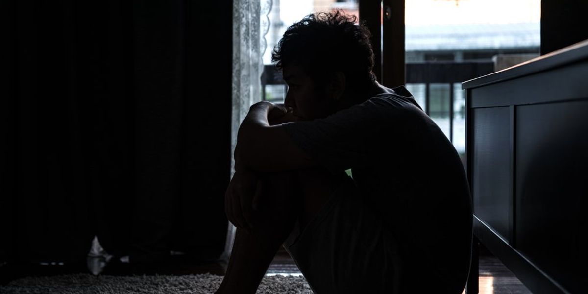 Depressziós férfi ül a padlón