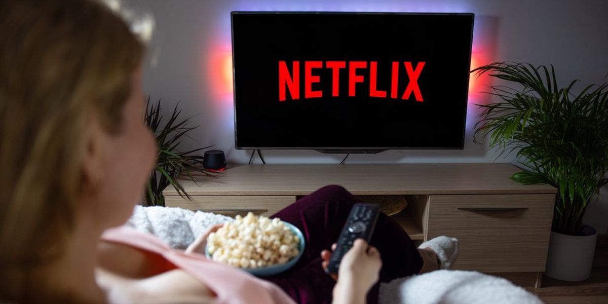 Fiatal nő popcornnal a kezében a Netflixet nézi