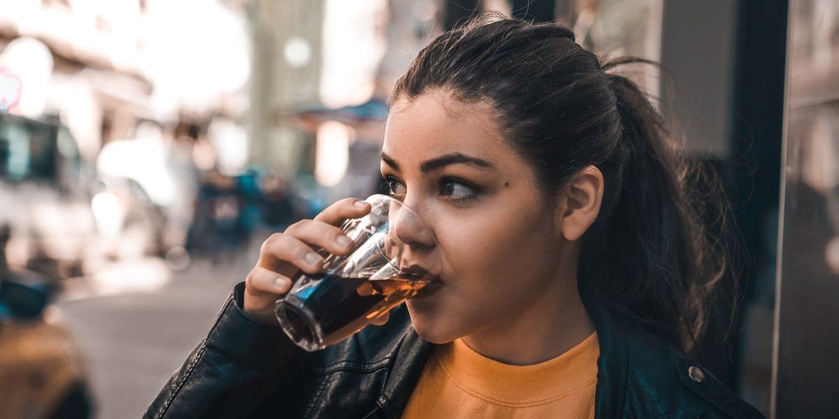 egy lány kólát iszik pohárból