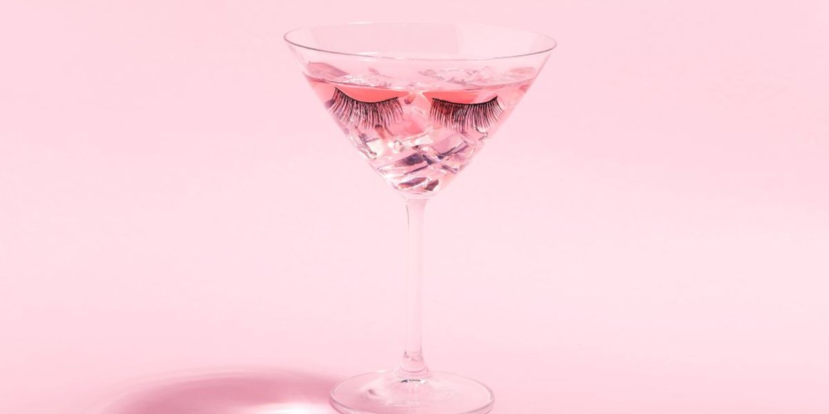 Koktél pohárban, szempillákkalm rózsaszín háttéren