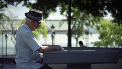 Egy idős férfi egy sakktábla felett ül