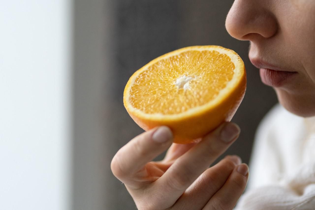 Egy nő narancsot szagol