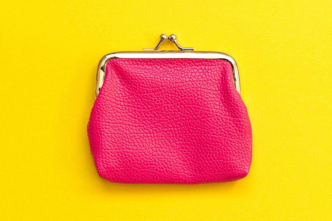 Rózsaszín pénztárca sárga háttér előtt