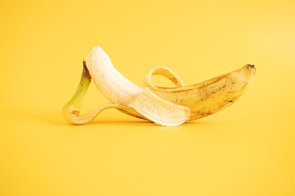 Hámozott, érett banán, sárga háttér előtt